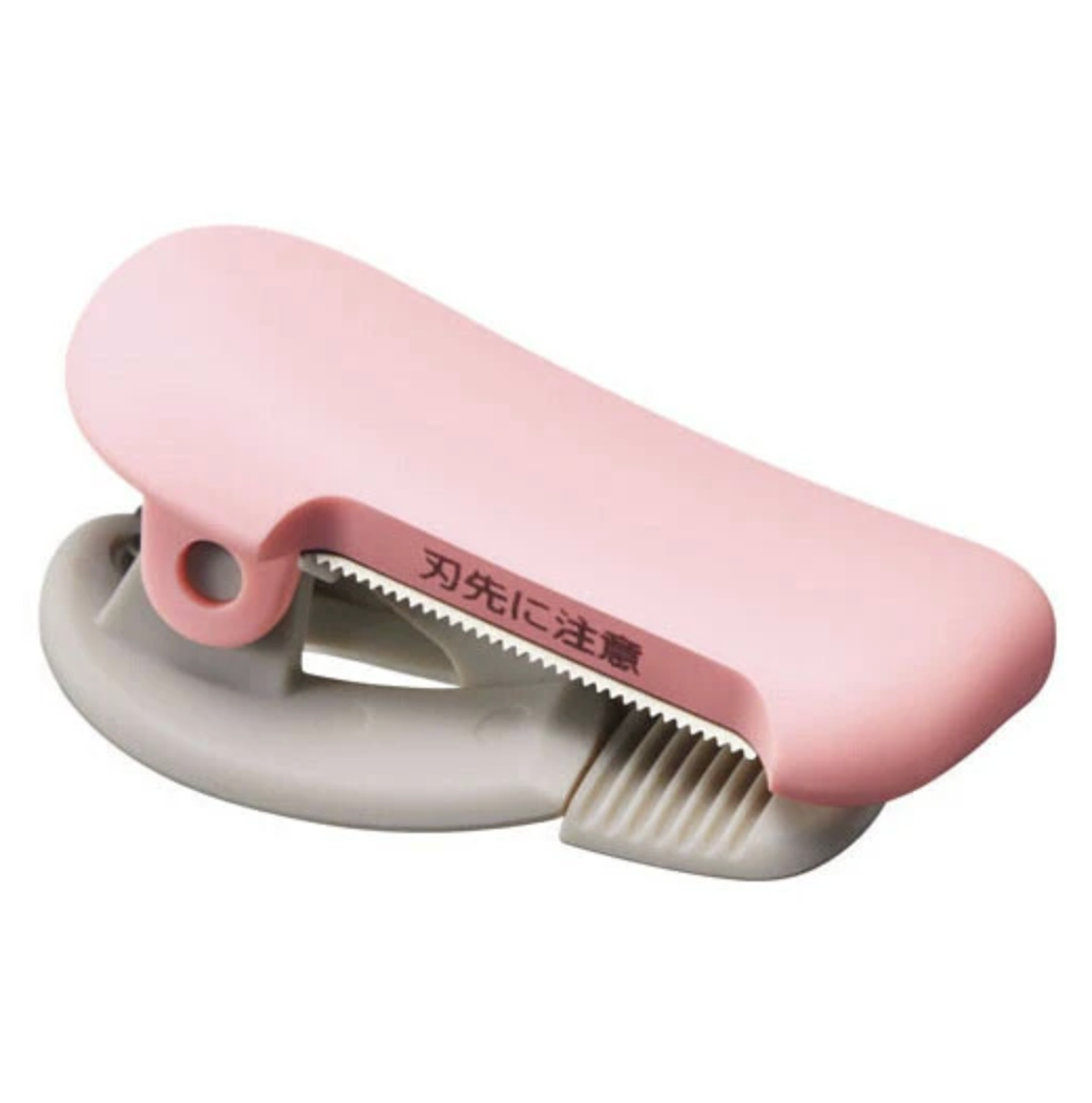 Pink and beige washi tape cutter on a white background