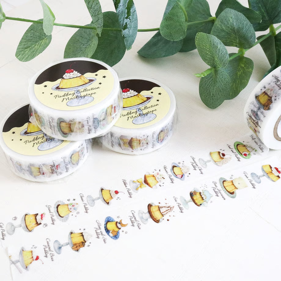 Sticker rolls with cake illustrations on a white surface with green leaves in the background
