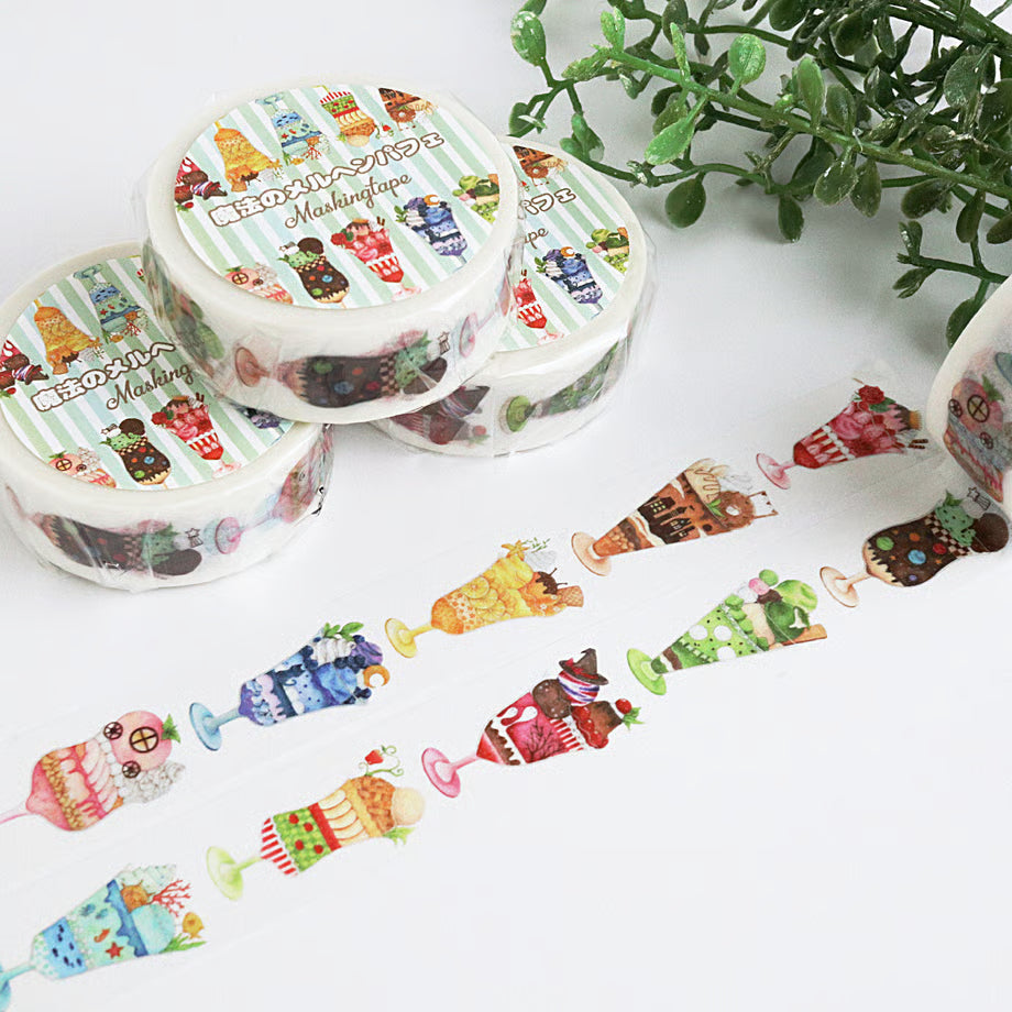Decorative tape with cartoon ice cream parfait on a white surface with green leaves in the background.