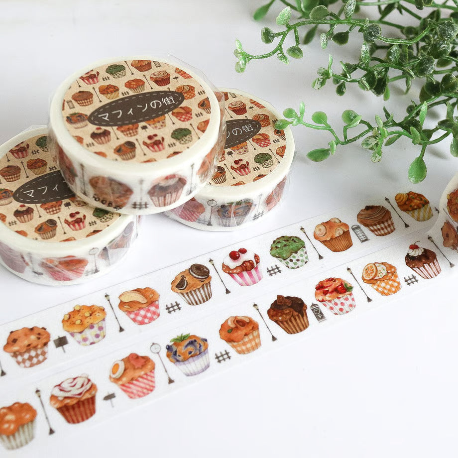 Decorative tape with cupcake design on a white surface with a plant in the background