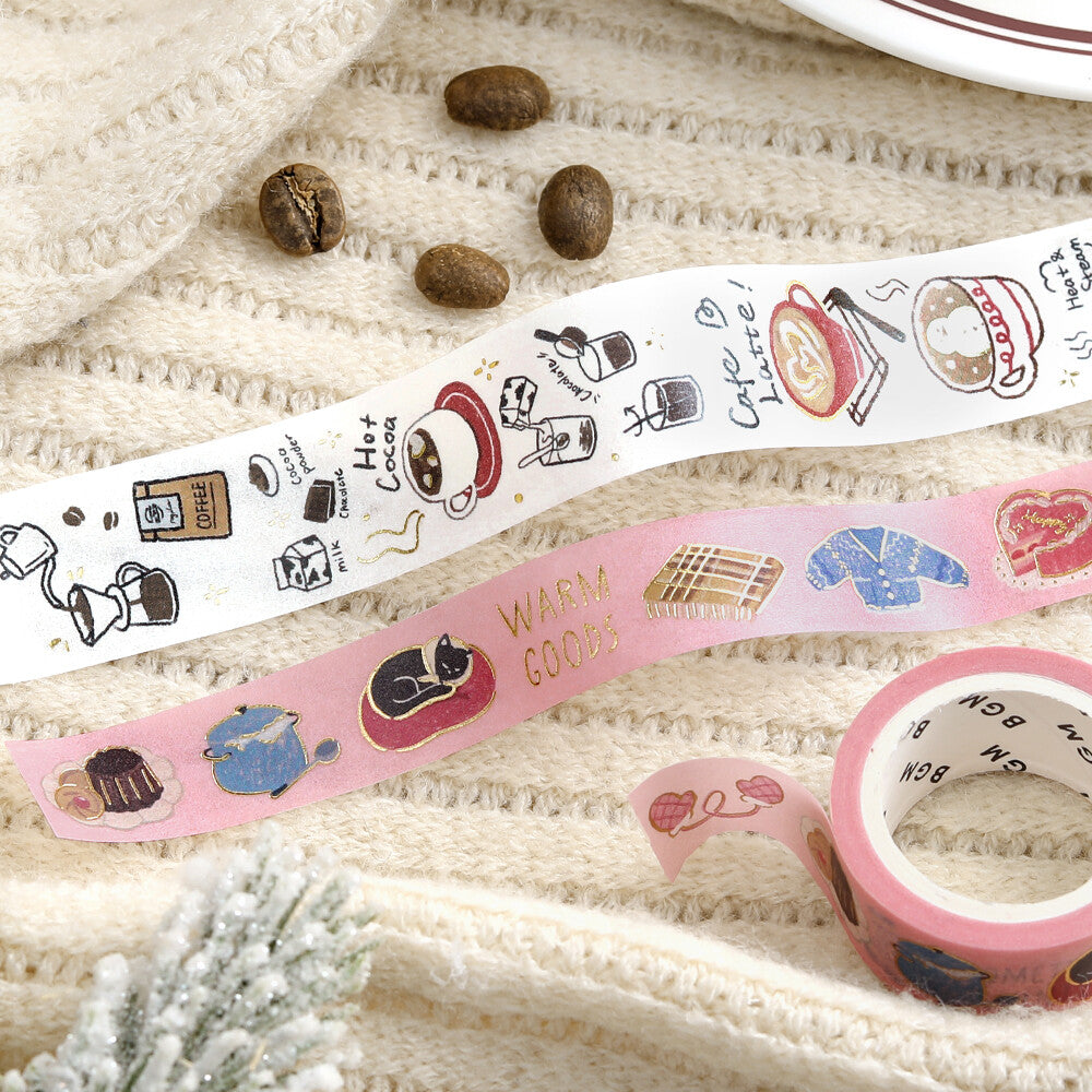Two rolls of decorative tape with coffee-themed designs on a textured surface.