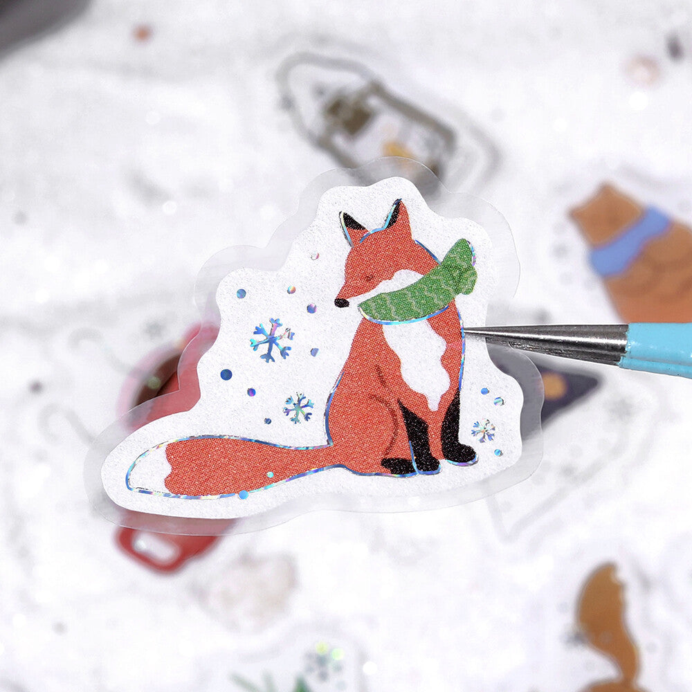 Sticker of a fox wearing a green scarf on a white background