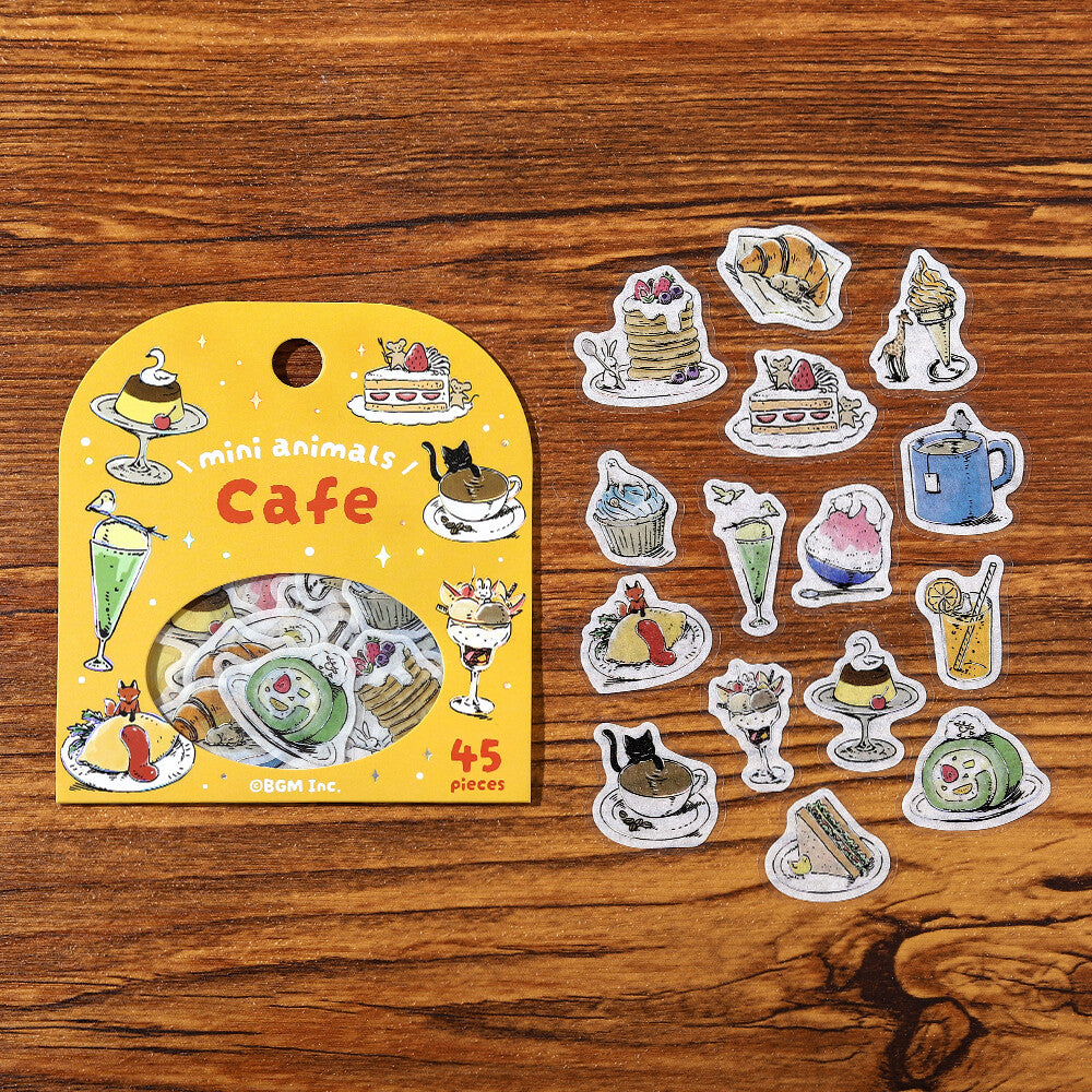Set of 'mini animals Cafe' stickers on a wooden surface with packaging.