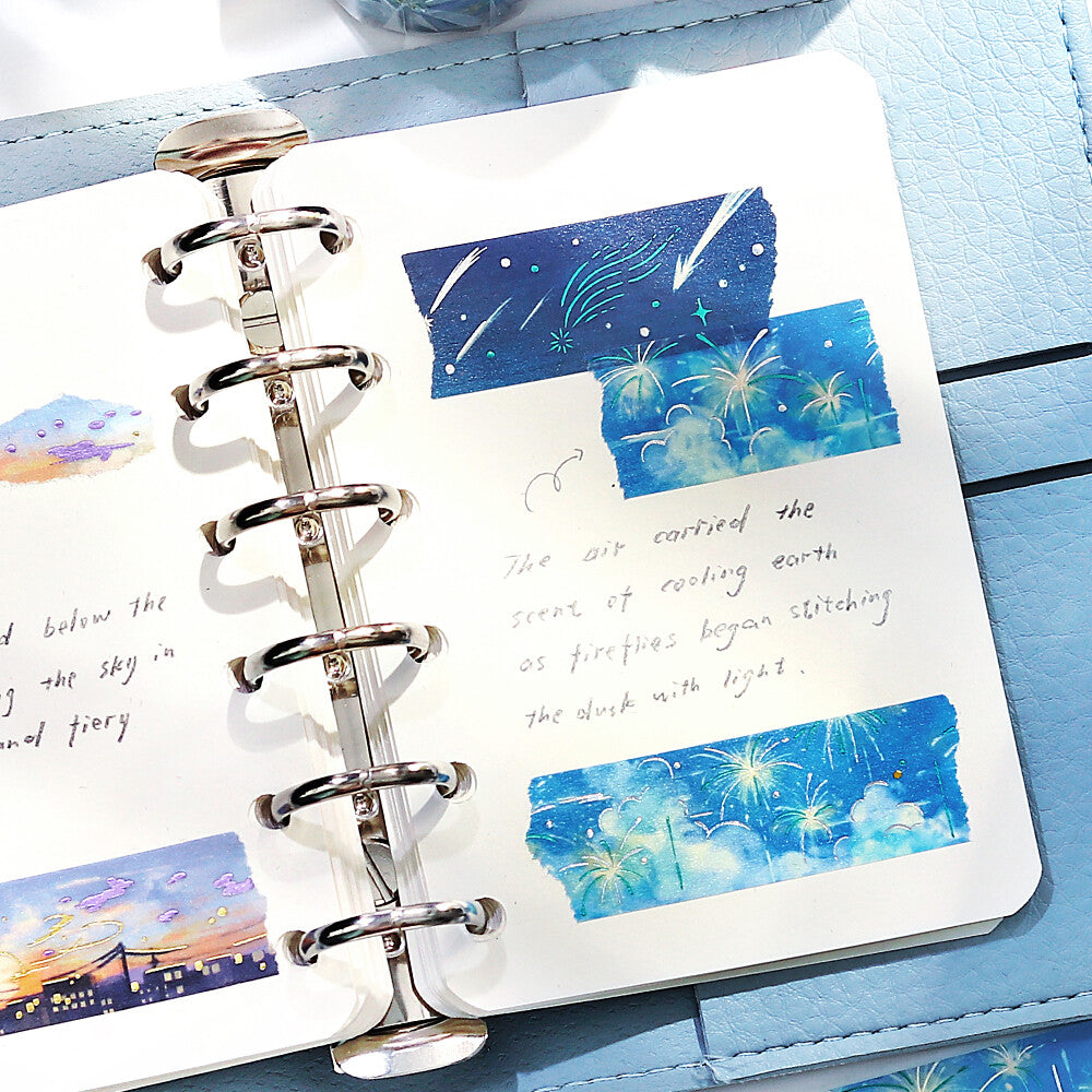 Notebook with spiral binding and watercolor illustrations of a night sky with stars and clouds.