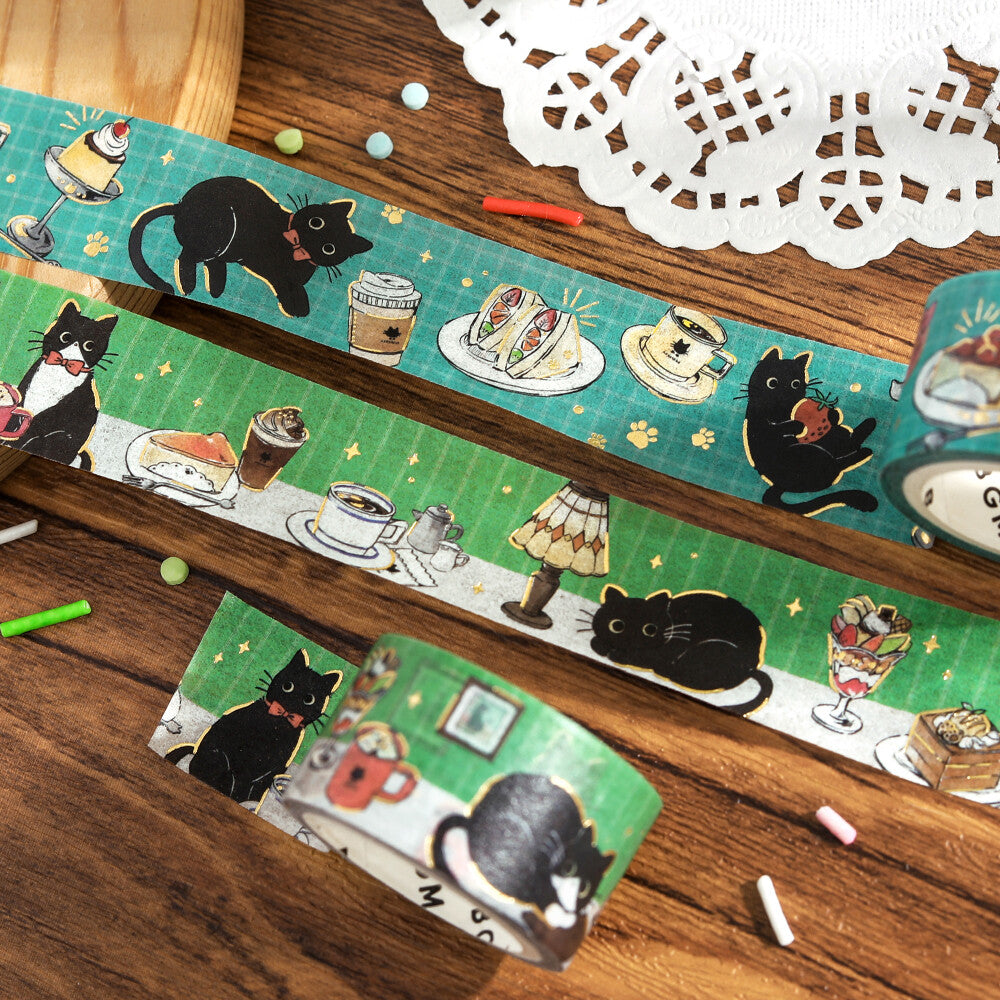 Washi tape with black cat and tea cup design on a wooden surface