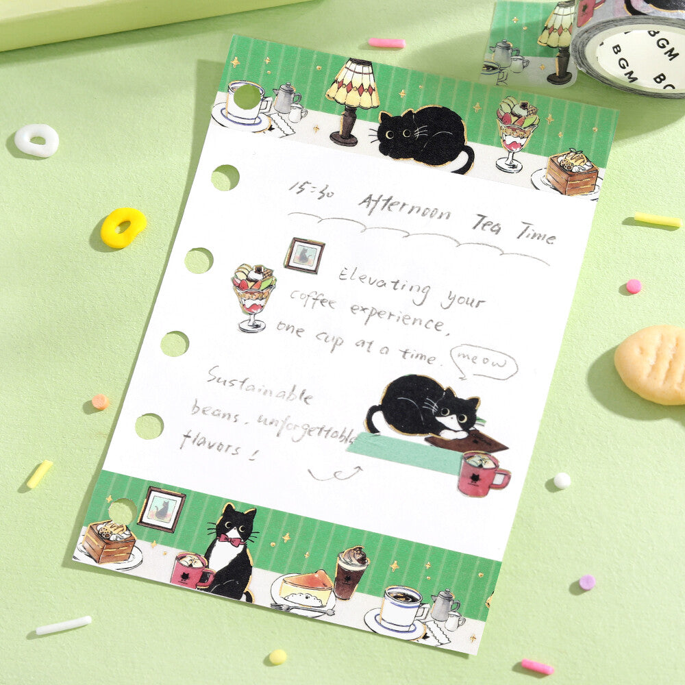 Sheet of paper with cat-themed illustrations and text on a green surface with scattered candies.