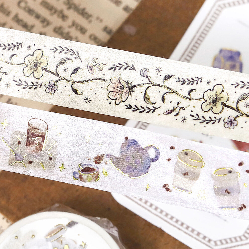 Decorative tape with floral design and another with tea-themed illustrations on a textured surface.