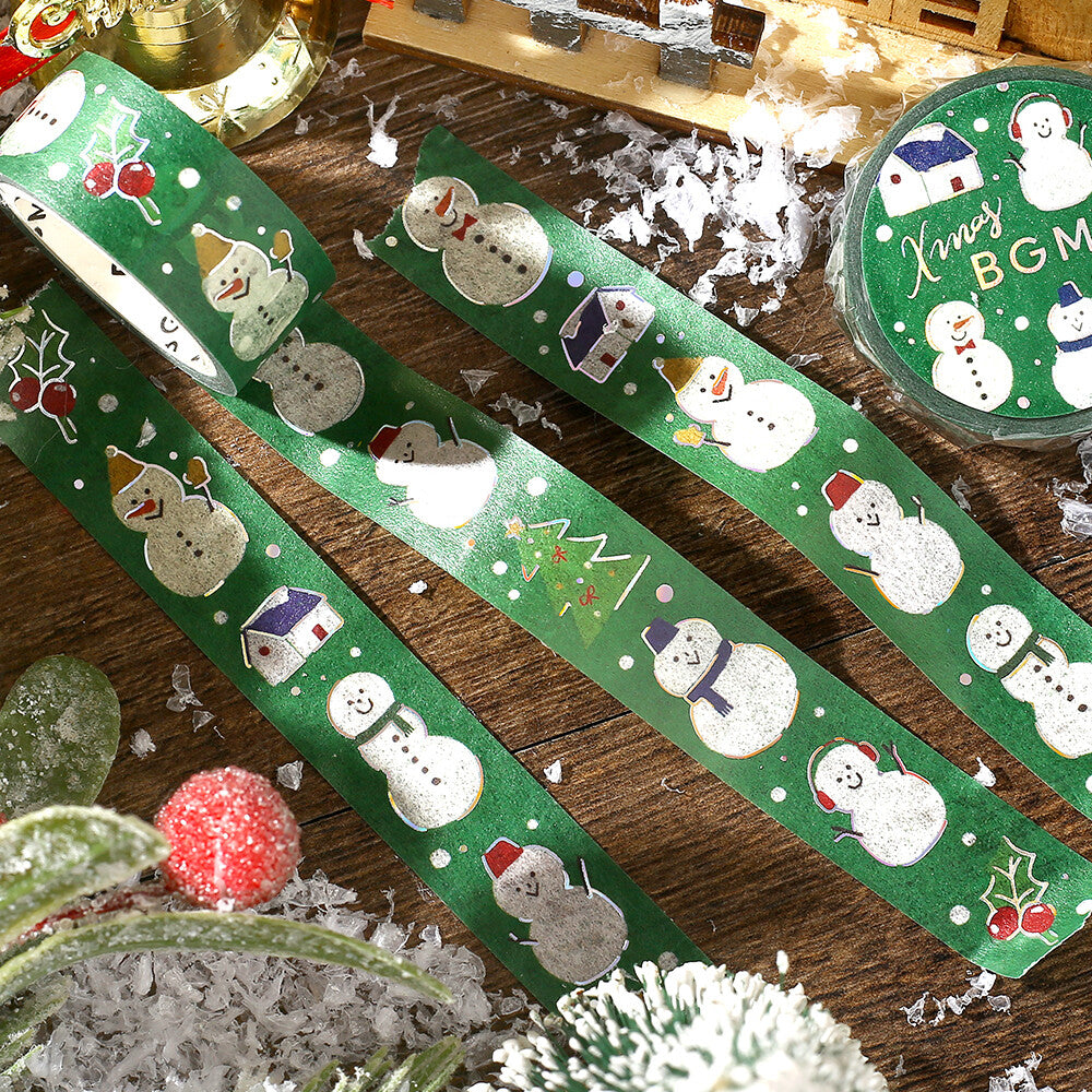 Green washi tape with Christmas designs on a wooden surface