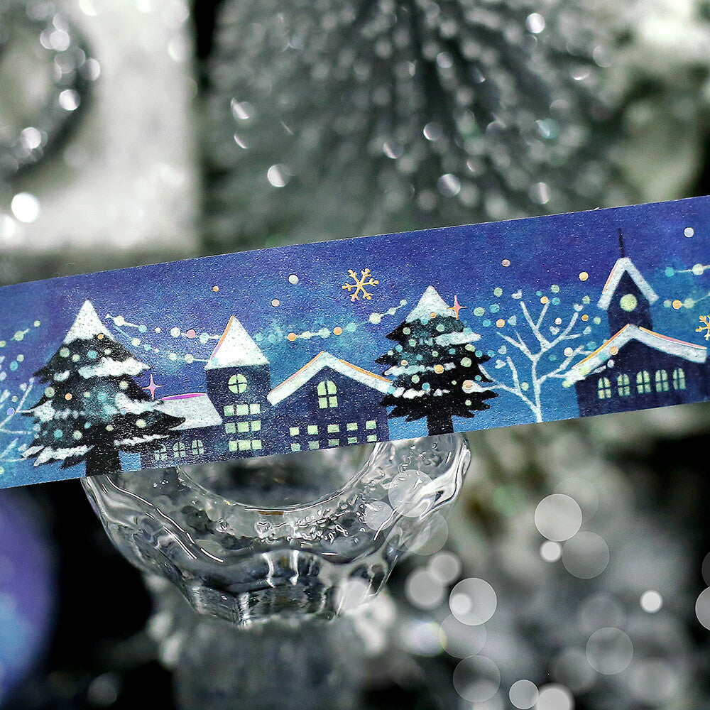 Decorative tape with winter scene design on a blurred Christmas tree background