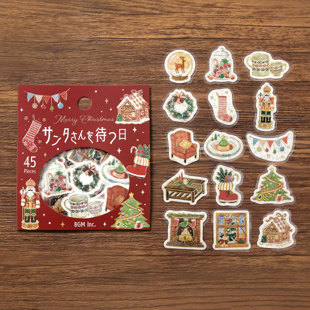 Set of Christmas-themed stickers with packaging on a wooden surface