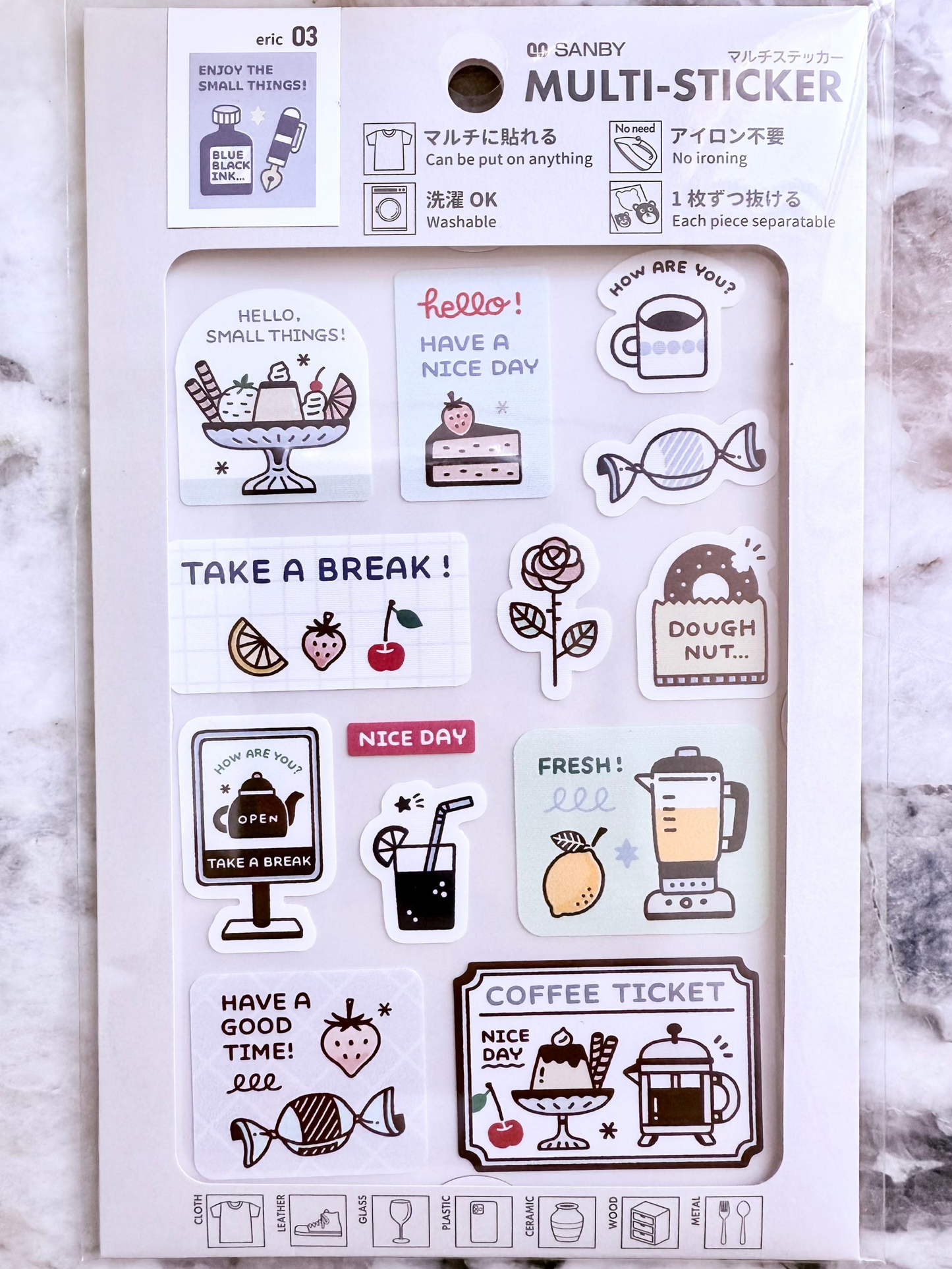 Packaging of a multi-sticker set with various illustrations on a marble surface