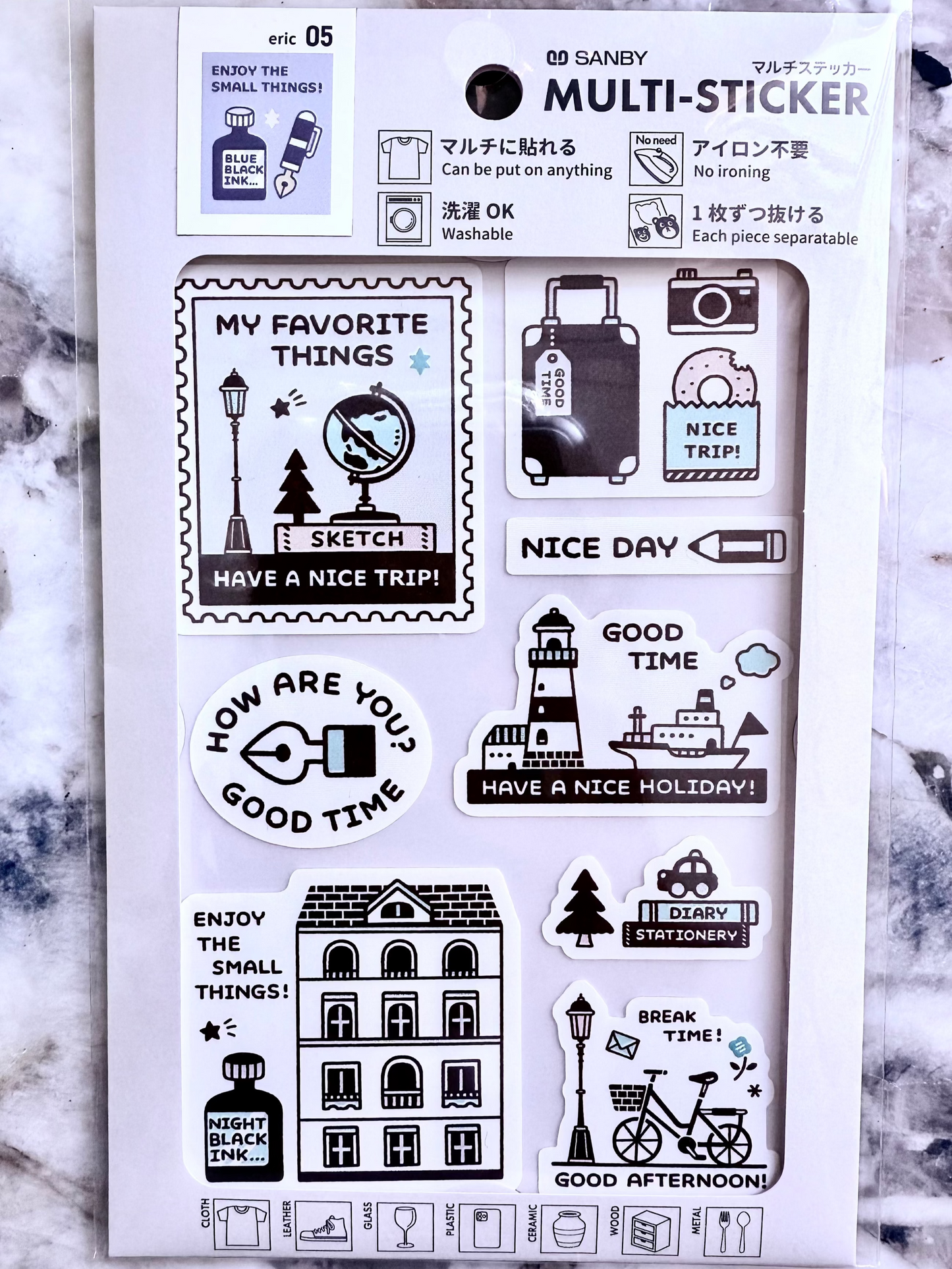 Set of black and white stickers on a white card with text, against a marble background.