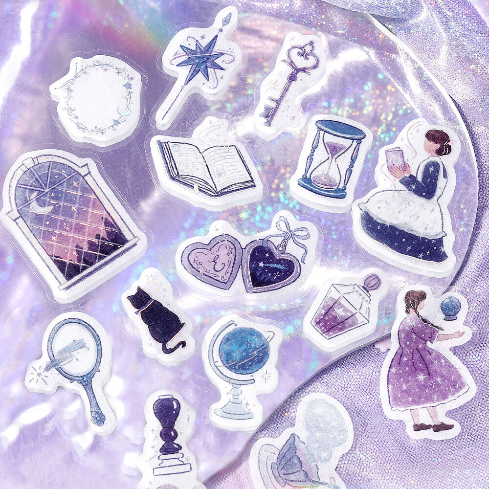 A collection of whimsical, illustrated sticker or decal designs arranged on a shiny, iridescent lavender surface. The designs include a witch's staff, a key, an open book, an hourglass, a girl in a white dress, a girl in a purple dress, hearts, a globe, a mirror, and other magical objects.