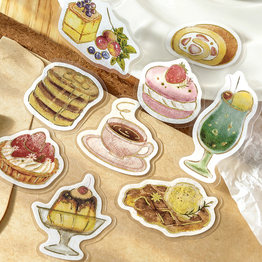 A set of die-cut stickers featuring watercolor illustrations of desserts, drinks, and a cup of coffee, arranged on a brown kraft paper background.