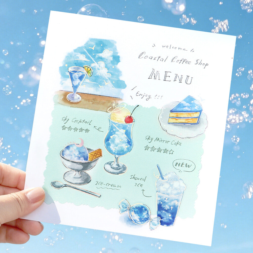 Hand holding a Coastal Coffee Shop menu with illustrations of drinks and desserts on a blue background.
