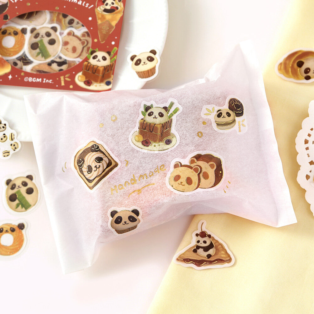 A white decorative sticker sheet featuring cute cartoon panda illustrations and small food-themed stickers, displayed on a soft cream background with a partial red package visible in the upper left.