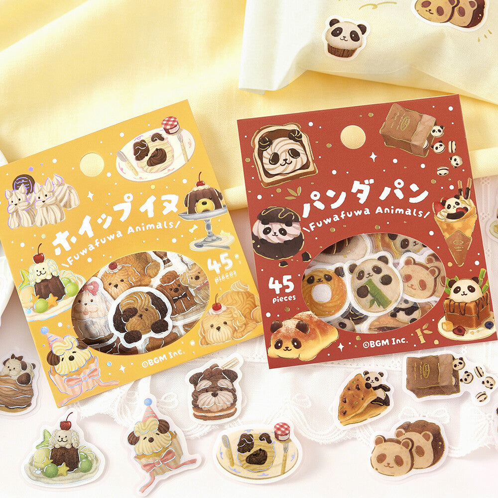 Two packages of cute cartoon animal-shaped stickers or charms displayed on a white surface with a pale yellow fabric backdrop. The left package is yellow and labeled 'Fuwafuwa Animals' with 45 pieces, and the right package is red and labeled 'Panda Pan' with 45 pieces.