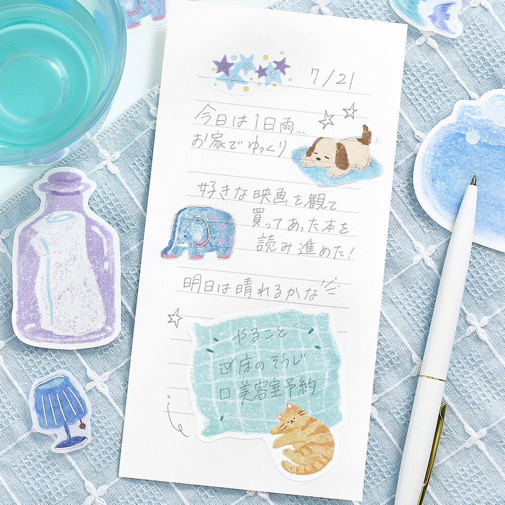 A letter with decorative stickers on it and writing on a blue cloth background