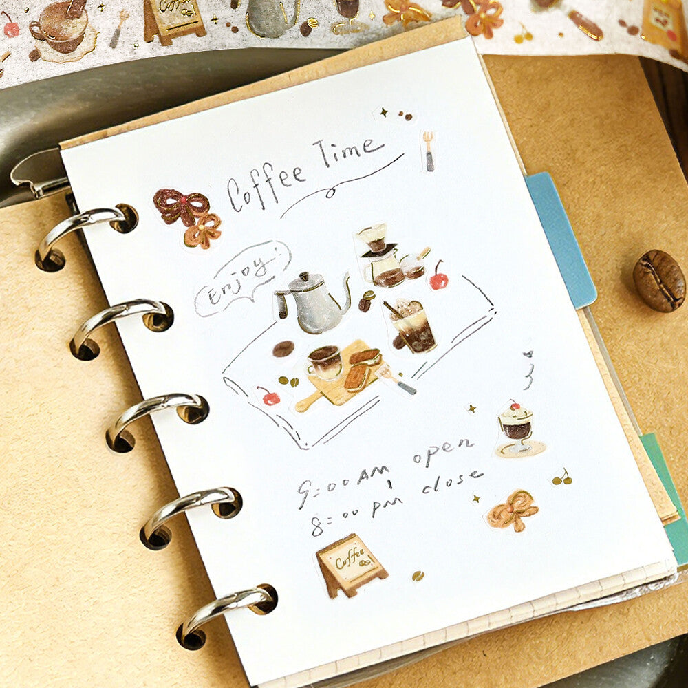 Planner with 'Coffee Time' stickers and illustrations on a wooden surface.