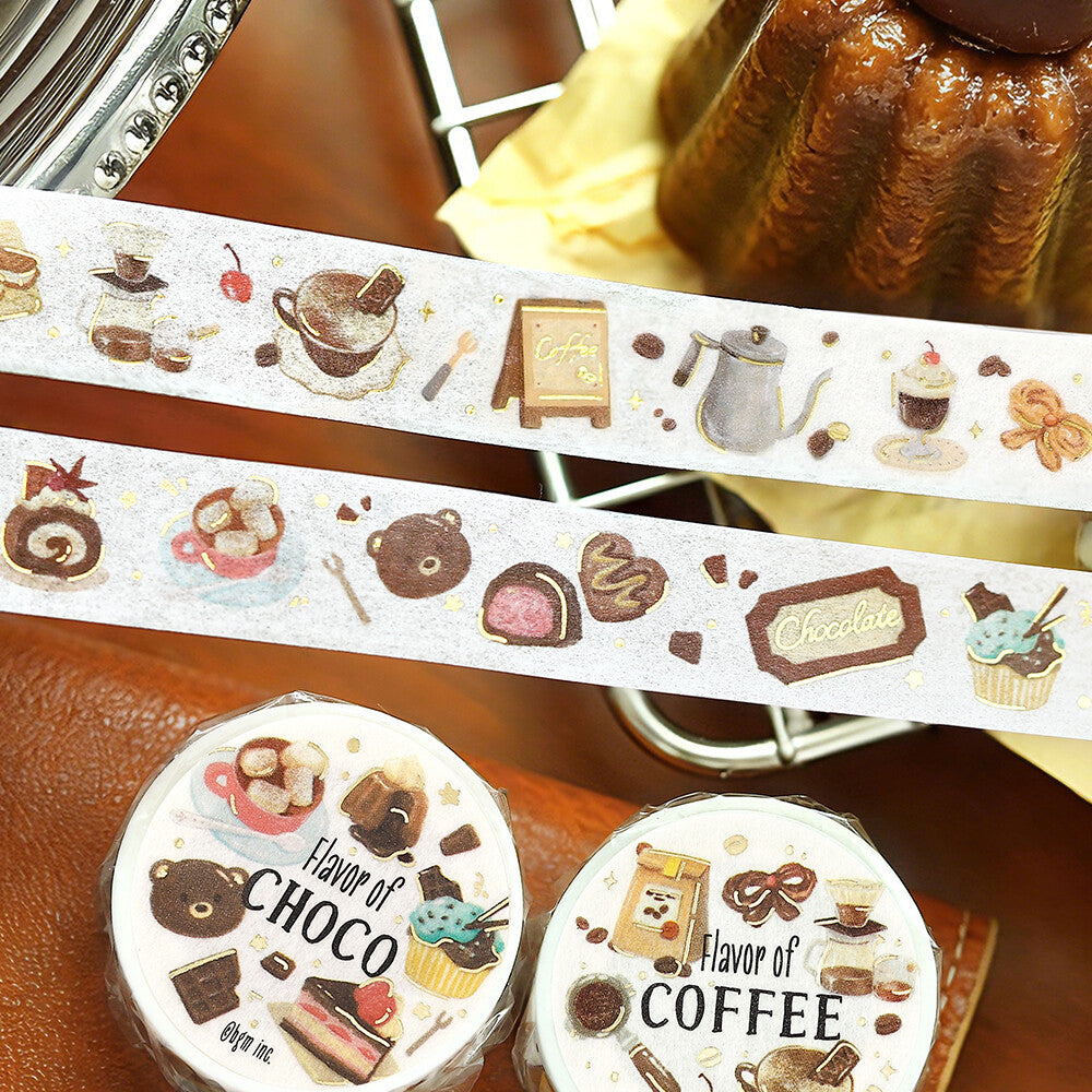 Two rolls of decorative washi tape with cute chocolate and coffee-themed illustrations, shown with the tape unrolled across a brown leather surface. The rolls are labeled 'Flavor of CHOCO' and 'Flavor of COFFEE'.
