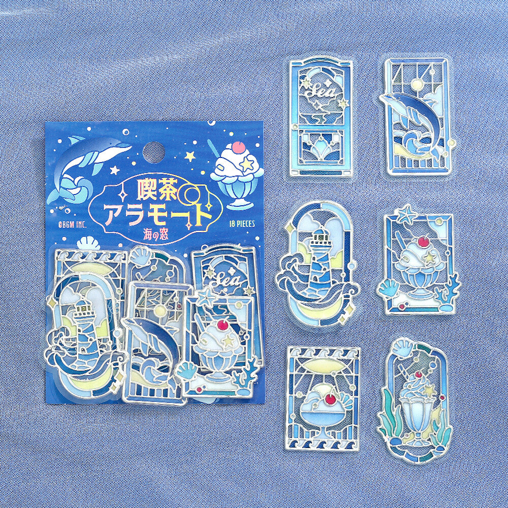 Packet of blue themed marine stickers with a stained glass design on a blue cloth background