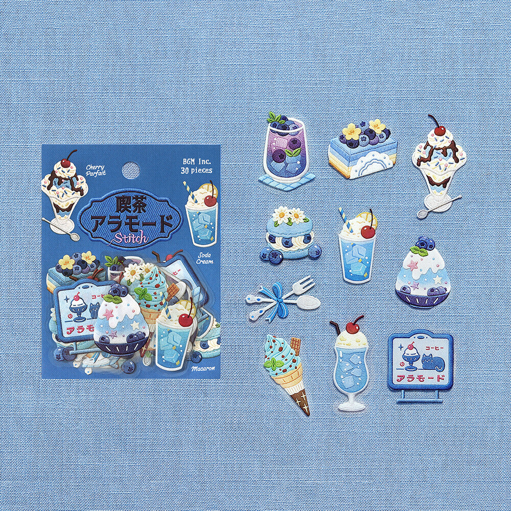 A range of dessert stickers from BGM Inc. is displayed on a blue cloth background