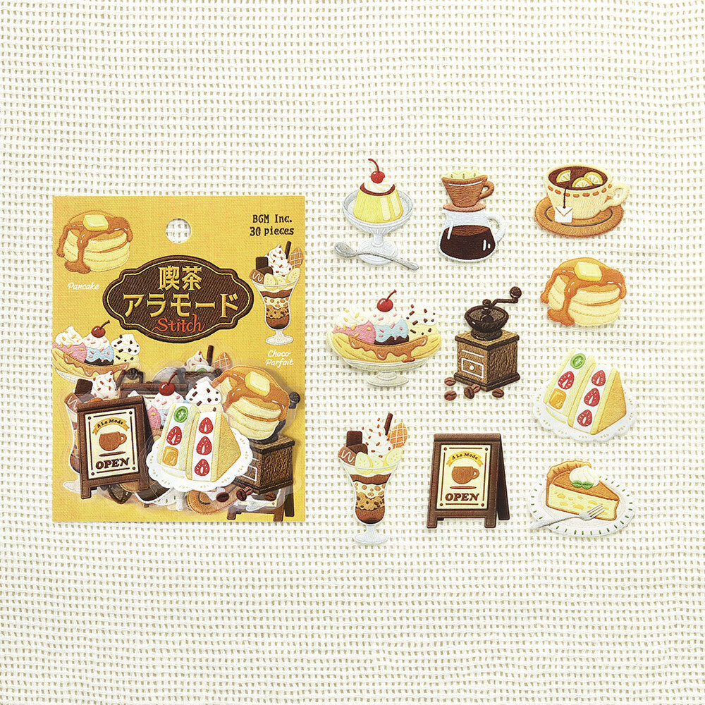 A set of Cafe themed stickers displayed next to their packaging on a textured white background. The stickers feature various retro-themed desserts, drinks, and signage in shades of yellow, cream, and red.