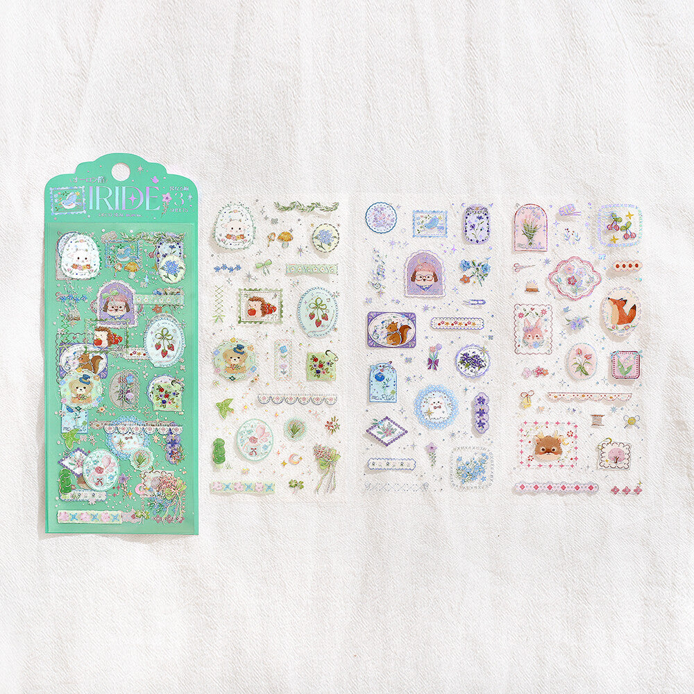 A mint green decorative sticker sheet set package labeled 'Iride' with pastel cartoon illustrations and small decorative elements, shown on a white cloth background 