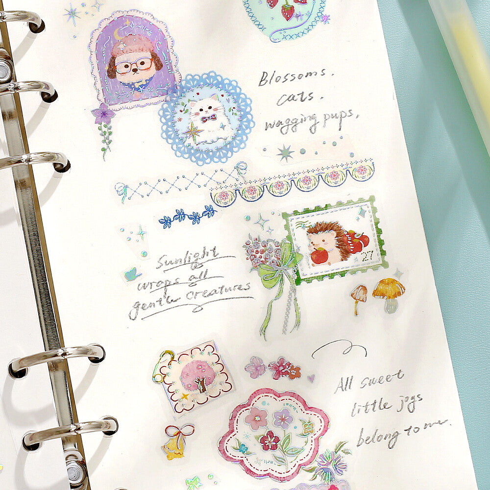 A decorative sticker page with pastel cartoon illustrations and small decorative elements, shown in a ring planner