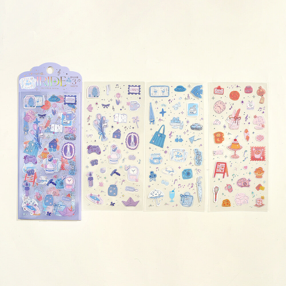 Three sheets of cute tea-time themed stickers displayed on a cream background, including a purple packaged sheet and three individual sheets with illustrations of cups, cakes, desserts, and teacups.