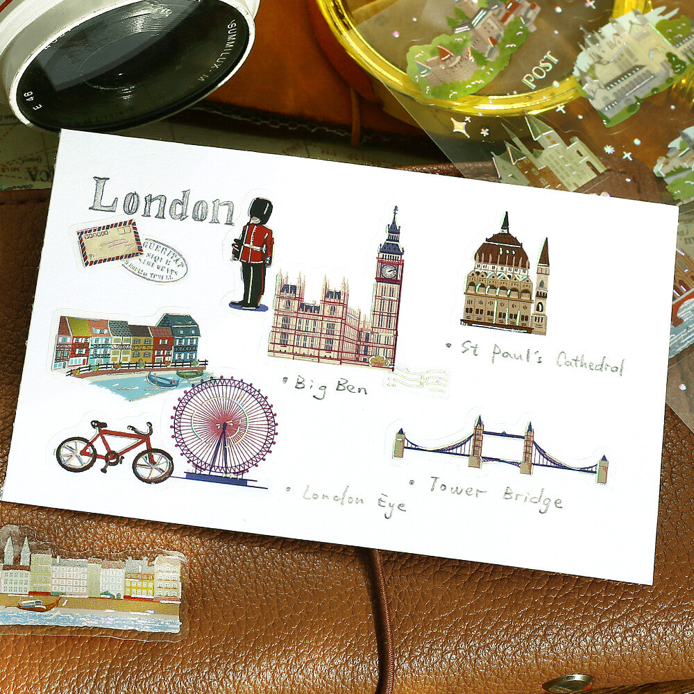 An envelope with decorative stickers shown on a planner background.