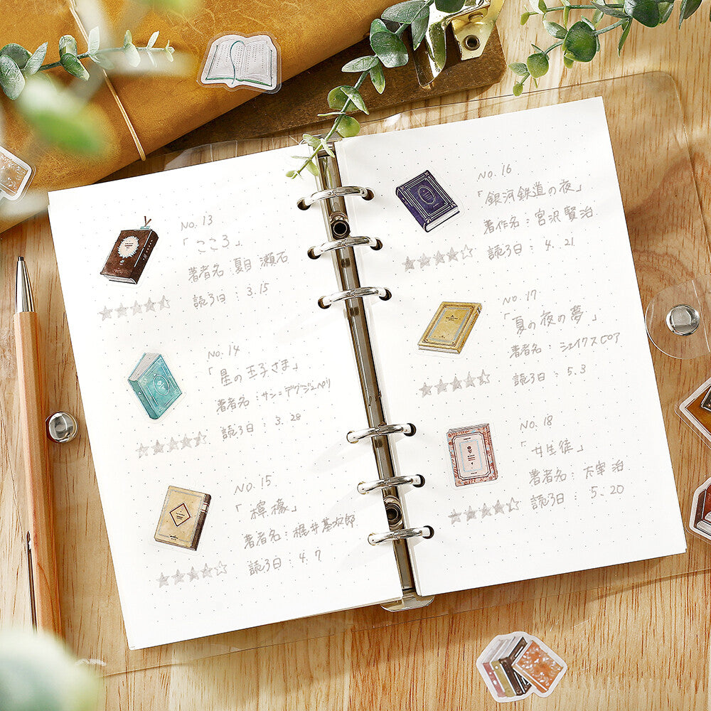 Open notebook with decorative stickers on a wooden surface