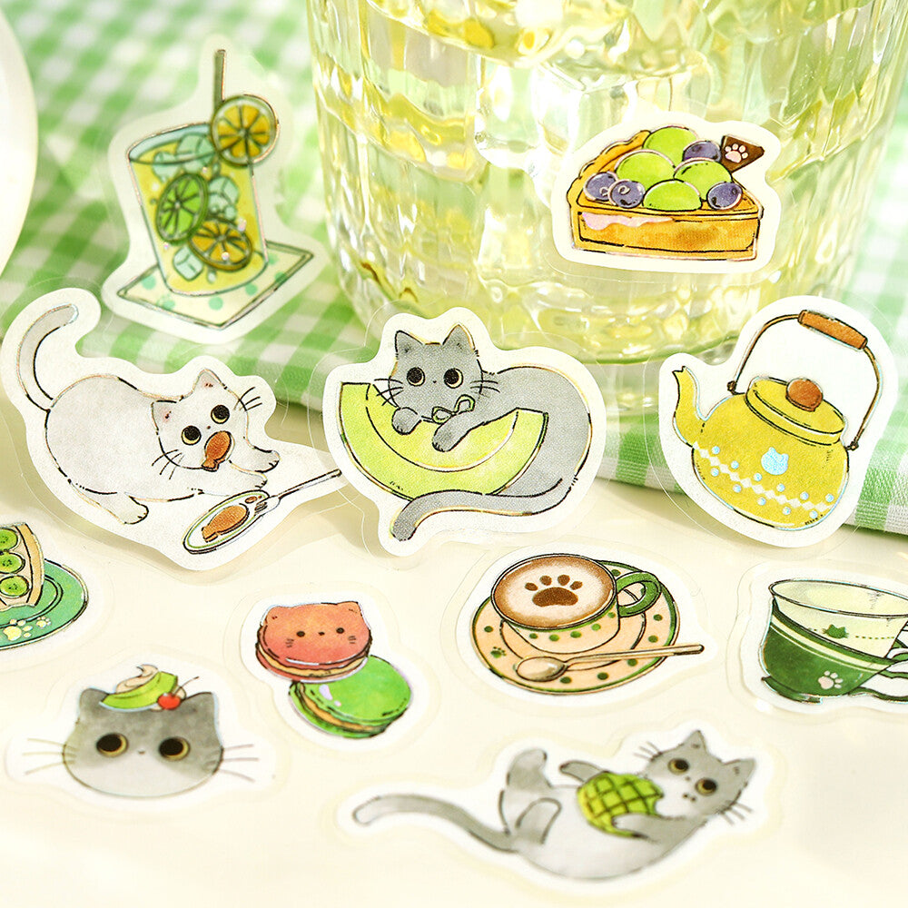 Set of cute cat-themed stickers on a checkered tablecloth with a glass of lemonade.