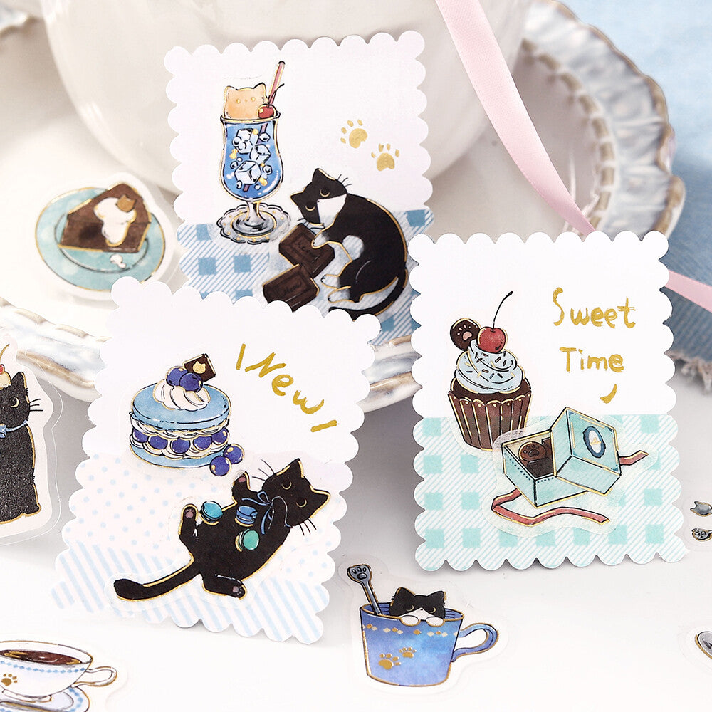 Sticker set with black cats, cakes, and other sweet-themed illustrations on a white background.