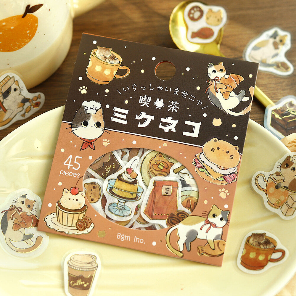 Pack of stickers with cat-themed designs on a wooden surface