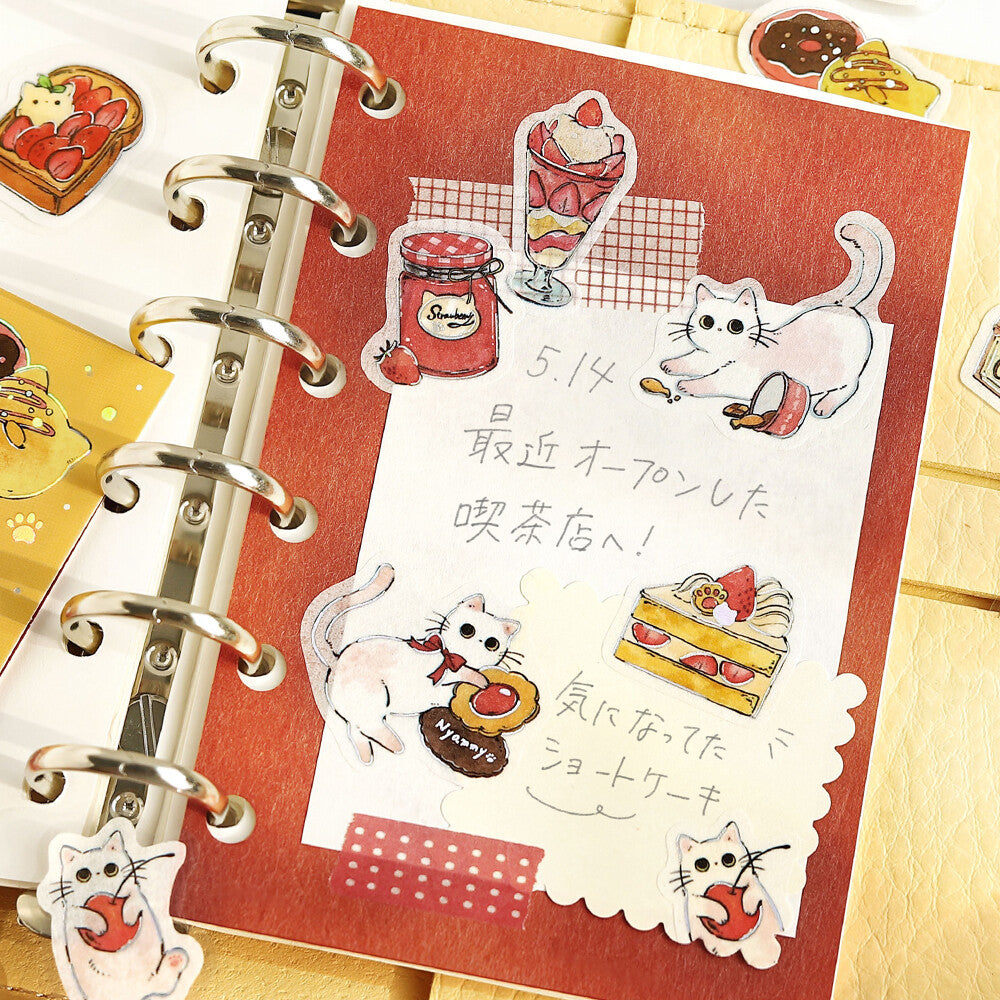 Planner with decorative stickers featuring cats, food, and text on a red background.
