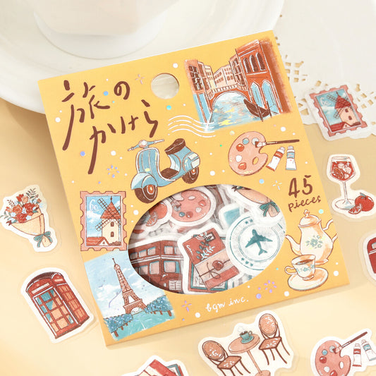 Sticker set with travel-themed designs on a yellow box, surrounded by additional stickers.