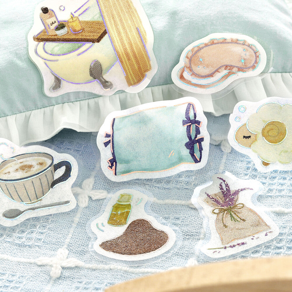 A close-up of cute illustrated stickers, surrounded by more matching sticker designs on a cloth surface.
