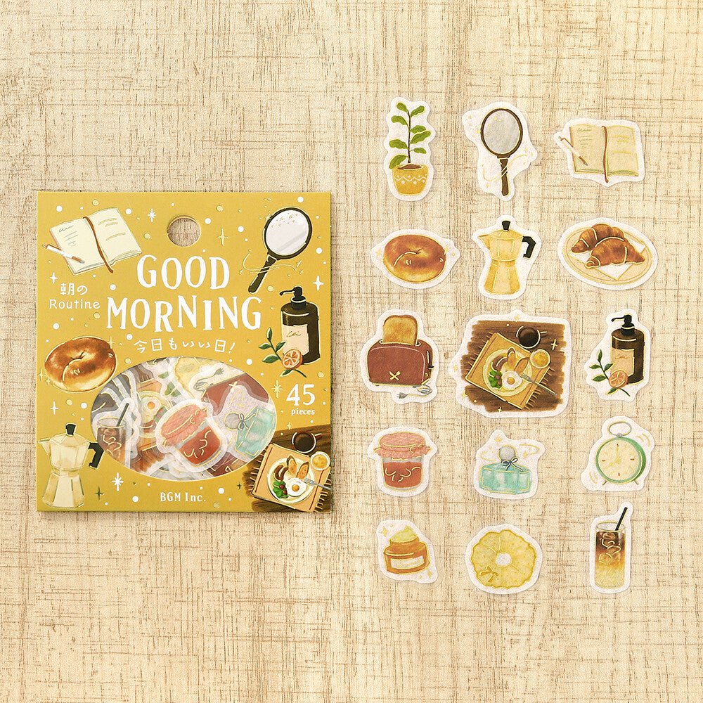 A set of morning themed stickers displayed next to their packaging on a textured wood background. The stickers feature various retro-themed breakfast items

