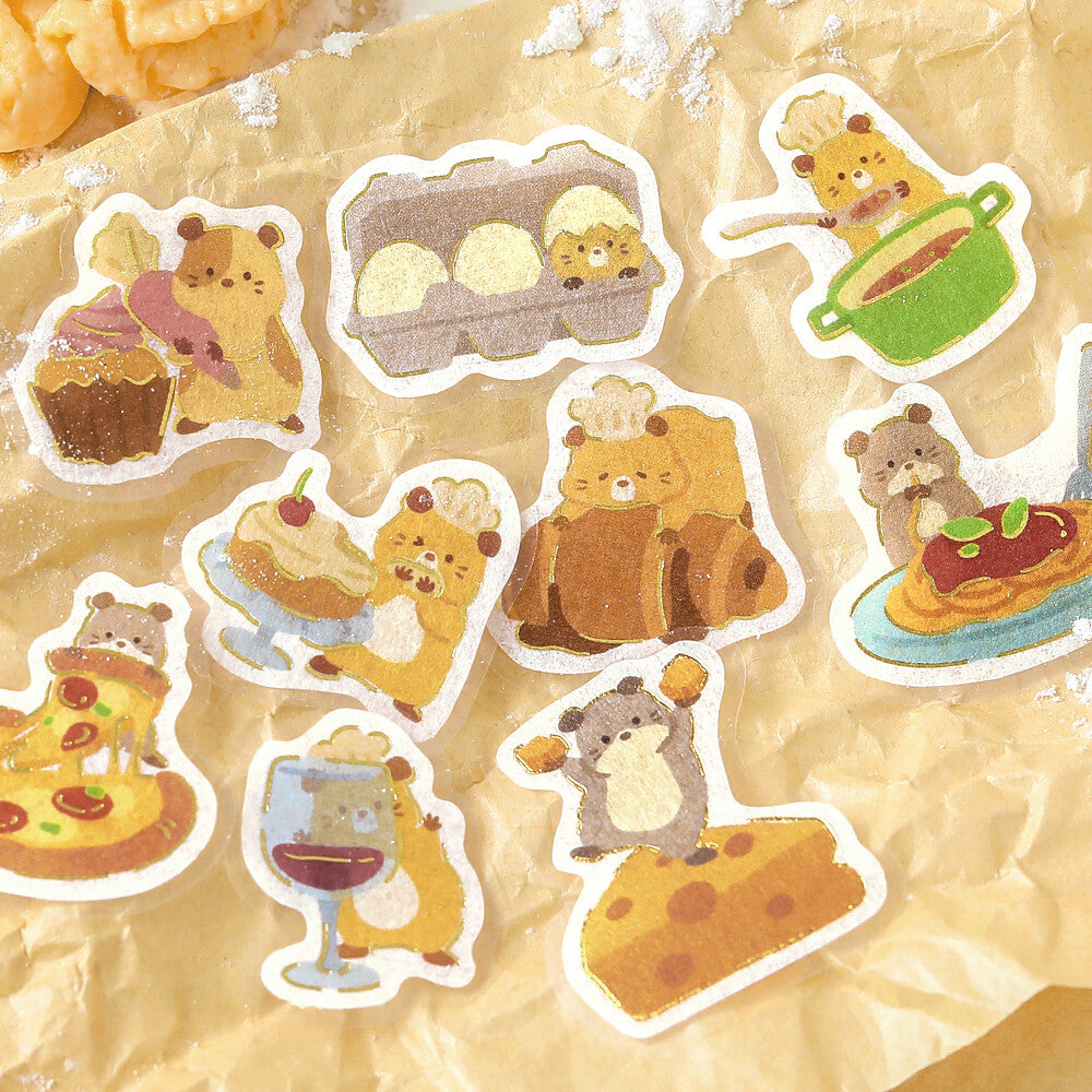 A close-up of hamsters printed on cute illustrated stickers, surrounded by more matching sticker designs on a paper surface.
