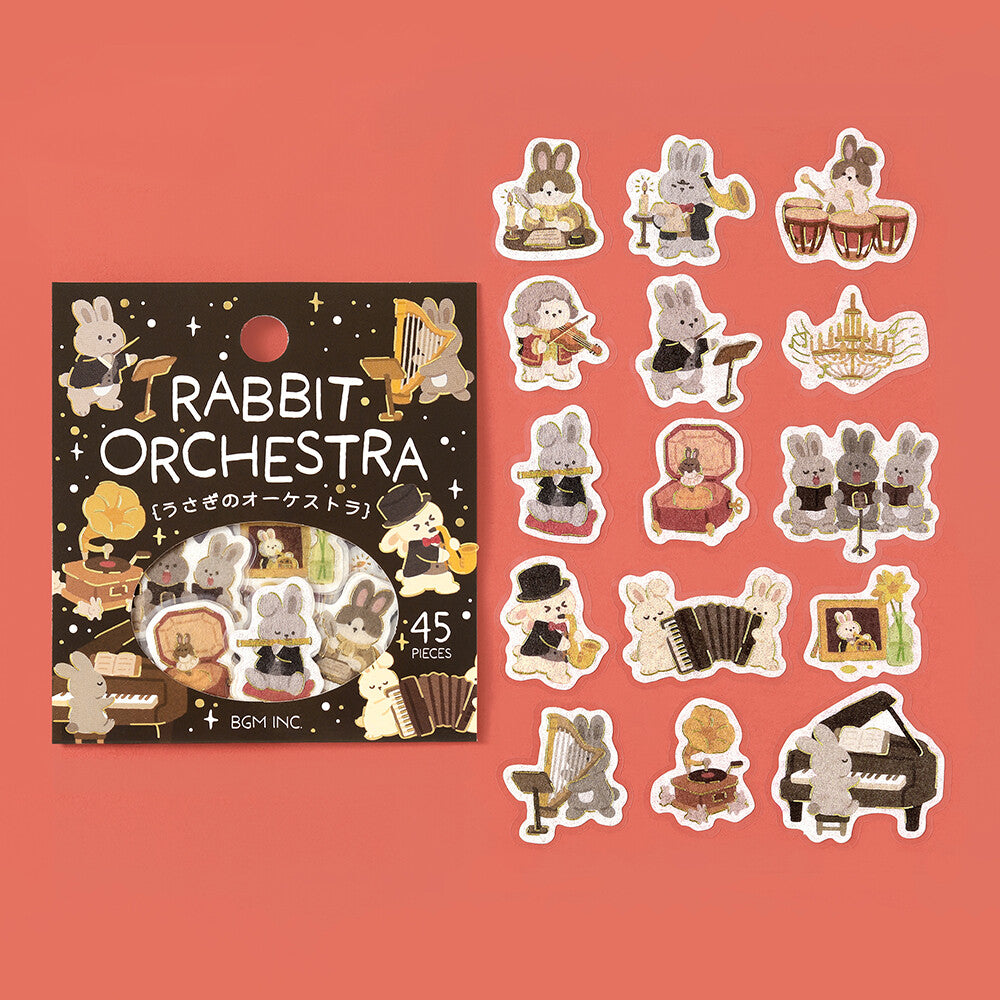 A set of rabbit orchestra themed stickers displayed next to their packaging on a red background.
