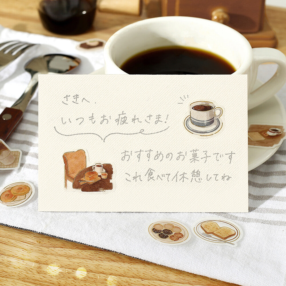 Note with coffee illustration and text on a table with a cup of coffee