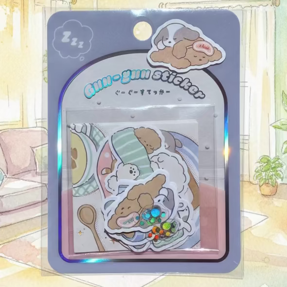 A package of cute cartoon dog stickers in a clear plastic blister pack with a gray backing card. The stickers feature various cozy scenes with brown and white dogs, including one with a rainbow pattern and another with a 'sleep' label.