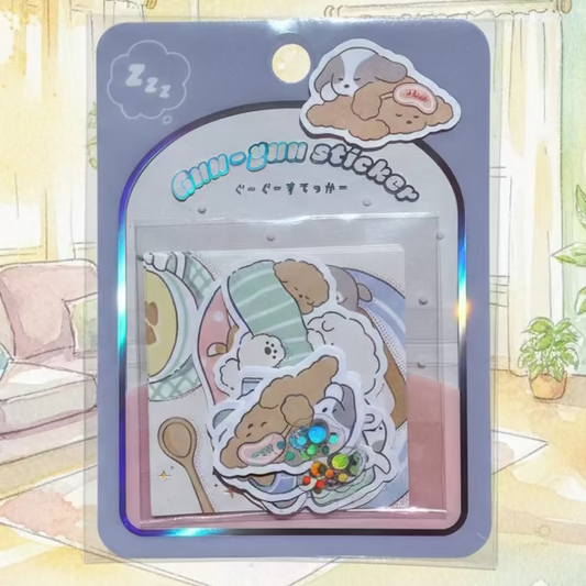 A package of cute cartoon dog stickers in a clear plastic blister pack with a gray backing card. The stickers feature various cozy scenes with brown and white dogs, including one with a rainbow pattern and another with a 'sleep' label.