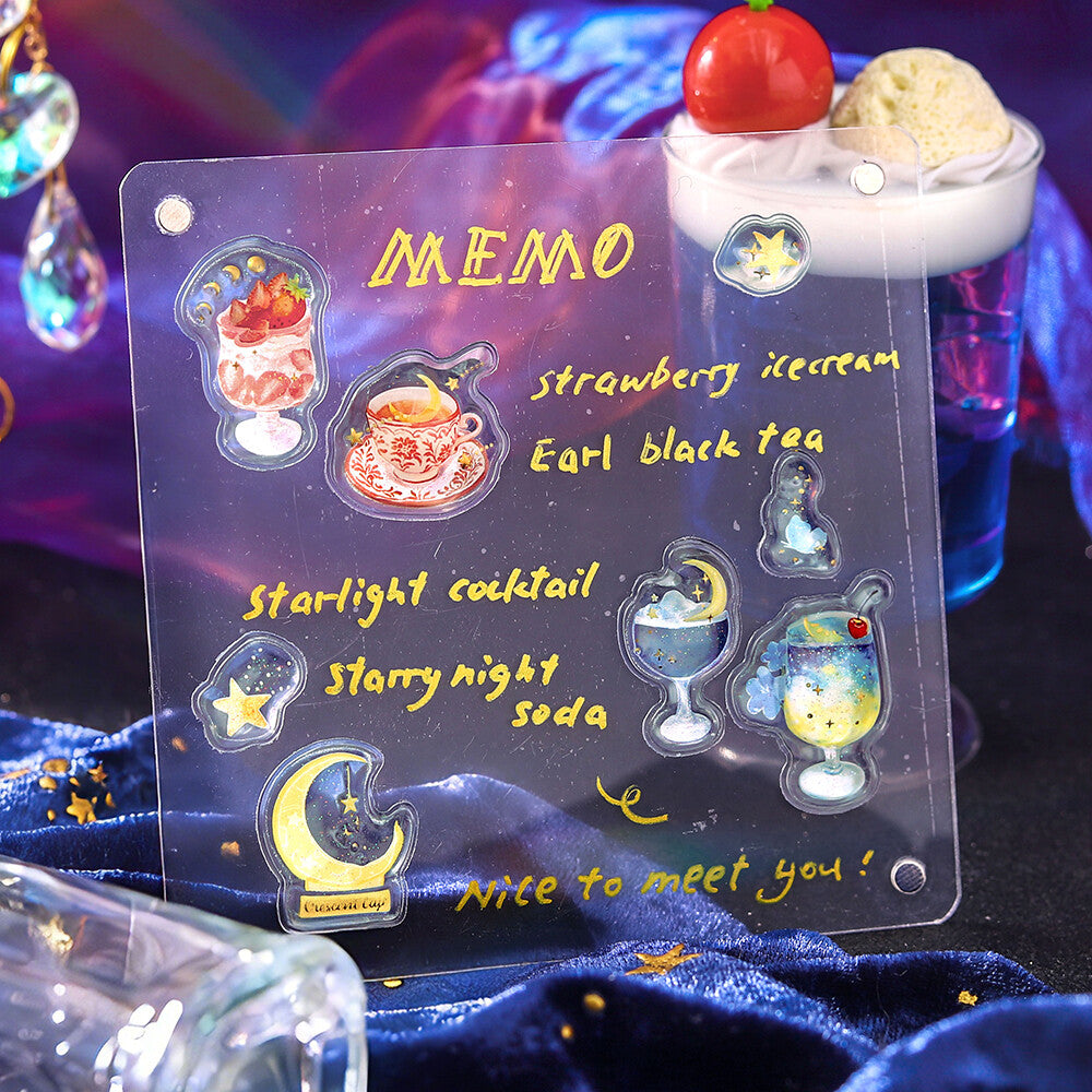 Transparent memo pad with starry night-themed stickers and text on a dark background
