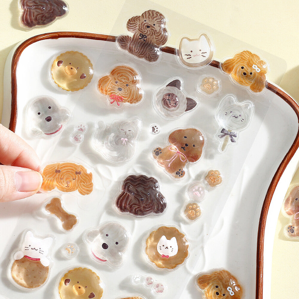 Set of cute animal-shaped cookies on a tray with a hand holding one cookie.