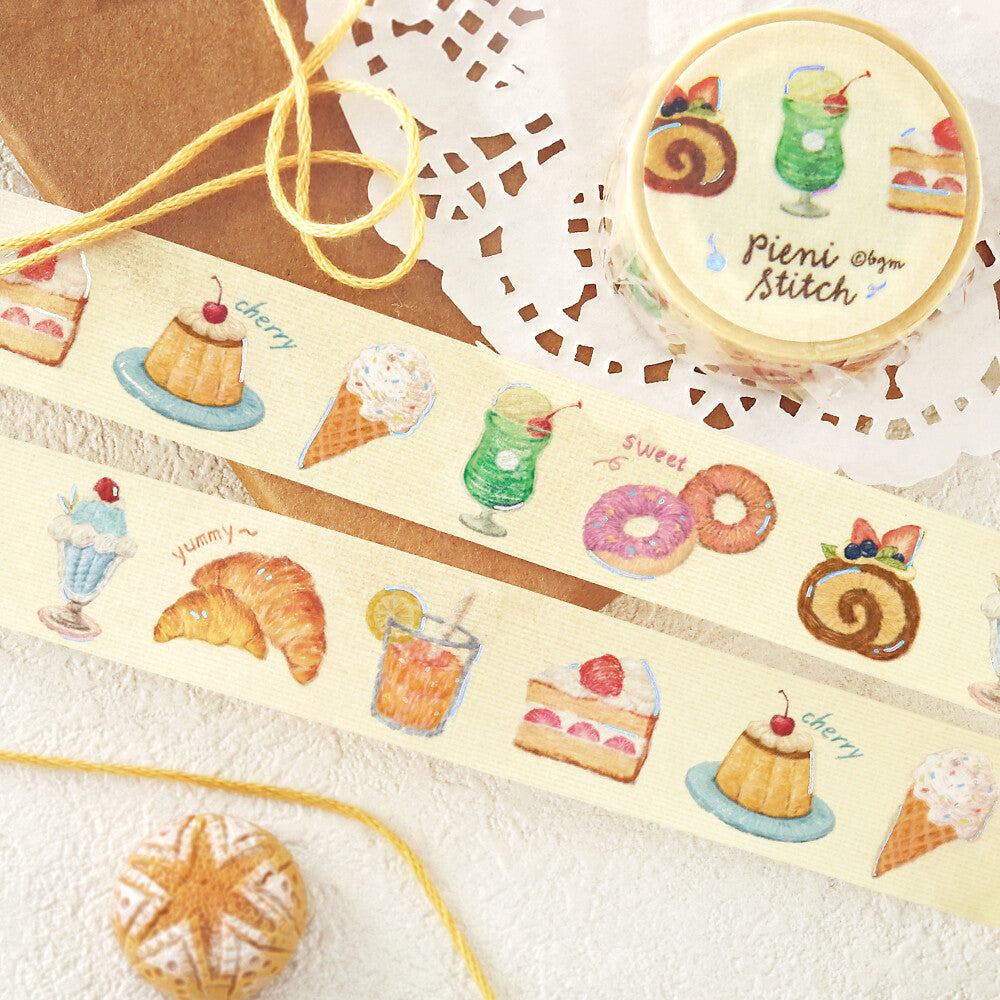 Decorative tape with food illustrations and a container labeled 'Pieni Stitch' on a lace doily.