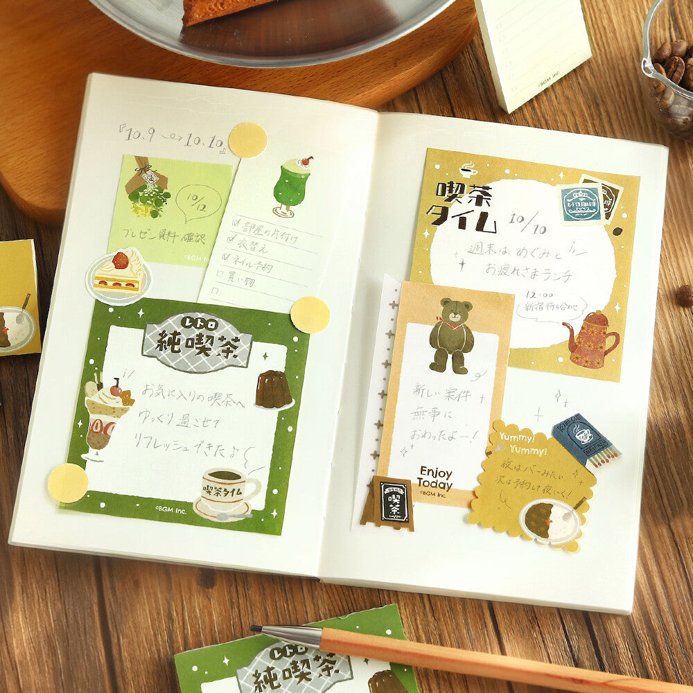 An open diary with memo pads decorated on the open pages on a wood surface