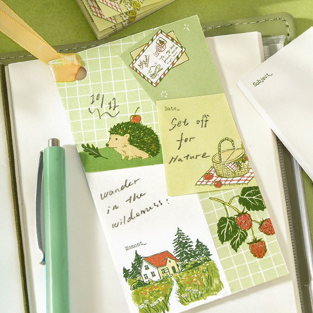 Decorative bookmark with green nature theme on a journal with a pen