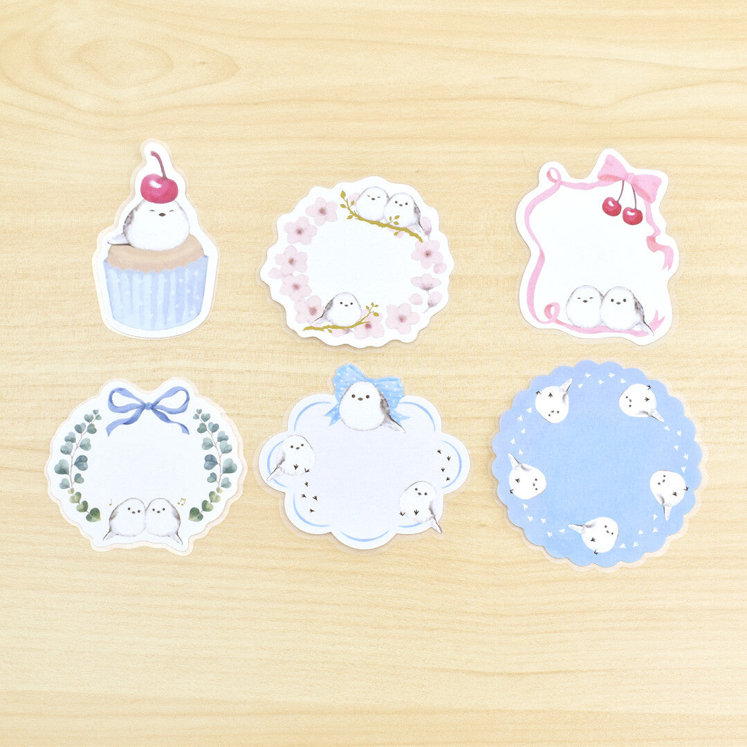 Set of six decorative stickers with cute designs on a wooden surface